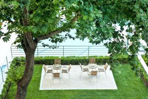 a patio with a table and chairs under a tree at Olympus Thea Boutique Hotel in Platamonas