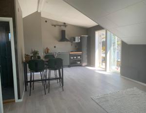 a kitchen with a table and some green chairs at Hamnhuset Björkö in Björkö