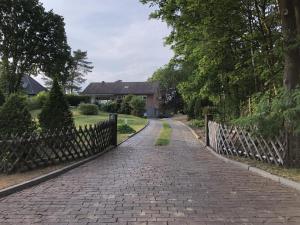un camino de ladrillo frente a una casa con una valla en am LaLoBe, Ferienwohnung, en Schneverdingen