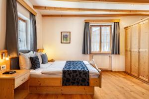 ein Schlafzimmer mit einem Bett in einem Zimmer in der Unterkunft Schreiberhof Landhaus in Lajen
