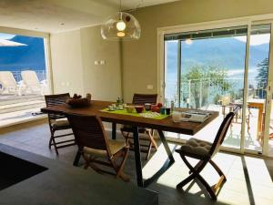 a dining room with a table and chairs and a large window at Villa San Sisinnio Argegno in Argegno