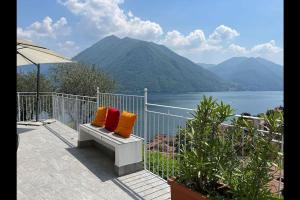 two pillows sitting on a bench overlooking a lake at Villa San Sisinnio Argegno in Argegno