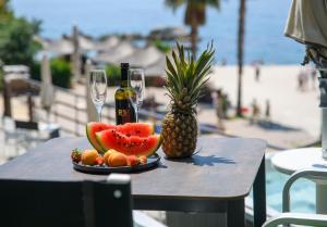 un plato de fruta y una botella de vino y una piña en Via Mare Luxury Rooms en Split