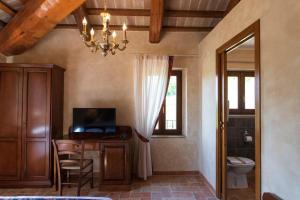a bathroom with a desk with a television and a window at Locanda di Montegiove in Fano