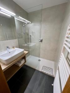 a bathroom with a glass shower and a sink at Zur Brücke in Mittewald - Your home in heart of South Tyrol, with Brixencard and free parking, ideal starting point for unforgettable excursions and outdoor adventures in Fortezza