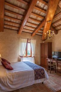 a bedroom with a bed and a desk and a television at Locanda di Montegiove in Fano