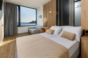 Via Mare Luxury Rooms في سبليت: غرفة نوم بسرير كبير مطلة على المحيط
