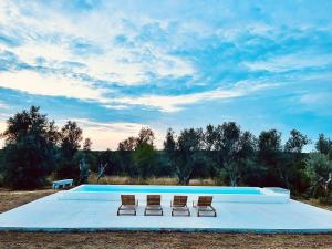 a swimming pool with two chairs and a poolvisorvisorvisor at Fazenda do Pomar by Trip2Portugal in Montemor-o-Novo