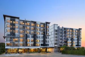 an apartment building with many windows at dusk at VST Residence in Samutprakarn