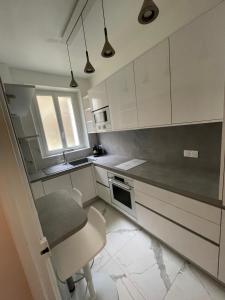 cocina con armarios blancos, mesa y silla en Montmartre sacré cœur, en París