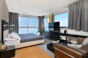 a bedroom with a bed and a tv and a couch at Hotel San Antonio in Podstrana