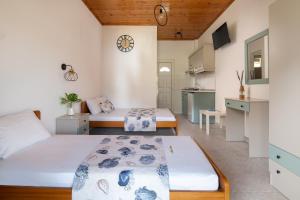 Dormitorio pequeño con 2 camas y cocina en Amo el mar Porto Koufo, en Porto Koufo