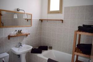 een badkamer met een wastafel en een bad bij Hotel L'Orangeraie in Le Lavandou