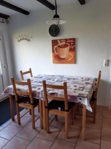 mesa de comedor y sillas con mesa y taza en Münchhausen EG en Wangerland