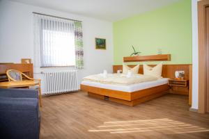 1 dormitorio con 1 cama y 1 sofá azul en Pension Böhm en Seligenthal