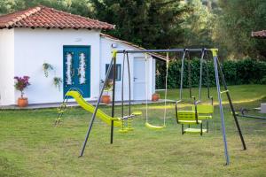 einen Spielplatz mit gelben Schaukeln im Hof in der Unterkunft Amo el mar Porto Koufo in Porto Koufo
