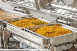 two metal trays of food in a buffet at Treebo Trend Paradise in Ahmedabad