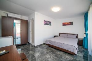 1 dormitorio con cama, escritorio y ventana en Vila Tributte, en Neptun