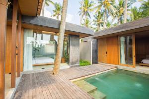 une maison avec une piscine à côté d'une maison avec des palmiers dans l'établissement Rumah Amadangi, à Tanah Lot