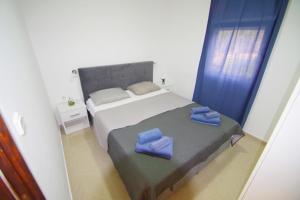 a bedroom with a bed with blue towels on it at Apartment Pineta in village Valbandon in Valbandon