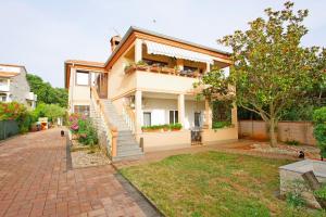 a house with a staircase in a yard at Apartment Pineta in village Valbandon in Valbandon