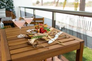 a table with wine glasses and food on a balcony at Apartamento Maypa 5 Mar in Meloneras