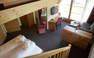 an overhead view of a bedroom with a bed and a television at Hotel Störes - Living Nature Hotel in San Cassiano