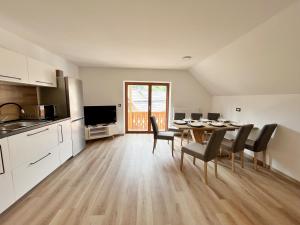 a kitchen and dining room with a table and chairs at Hiša Grilc in Kranjska Gora