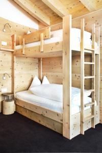 2 letti a castello in una camera in legno di Hotel Störes - Living Nature Hotel a San Cassiano