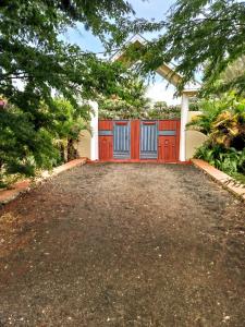 un garage con porte rosse e un vialetto di Heart Of Africa Adventure and Apartments ad Arusha