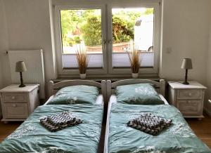 1 dormitorio con 2 camas y ventana en am LaLoBe, Ferienwohnung en Schneverdingen