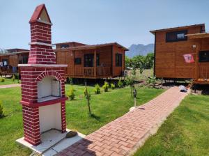 a brick brick oven in a yard with a house at Ugur Pansiyon Bungalows in Cıralı