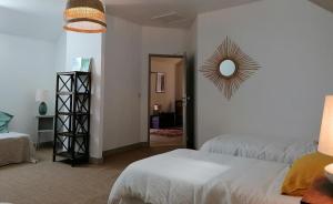 - une chambre avec un lit et un miroir mural dans l'établissement La Robinière Maison d'Hôtes, à Mont-près-Chambord