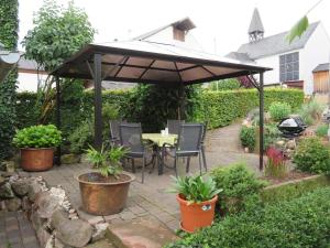 un patio con mesa y sillas bajo una sombrilla en Ferienwohnung Scheer, 