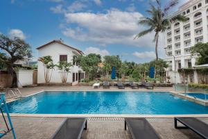 a swimming pool in front of a building at Praha Hotel in Phu Quoc
