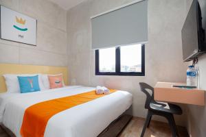 - une chambre avec un lit, un bureau et une chaise dans l'établissement Sans Pasar Lama Tangerang, à Tangerang