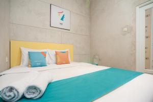 a bedroom with a bed with blue and orange pillows at Sans Pasar Lama Tangerang in Tangerang