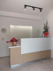 a white counter in a room with a vase of flowers at Minoica Beach Apartments in Amoudara Herakliou +50 photos