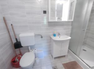 biała łazienka z toaletą i umywalką w obiekcie Viktória Panzió Zamárdi w Zamárdi