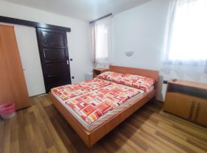ein Schlafzimmer mit einem Bett mit einer Bettdecke darauf in der Unterkunft Viktória Panzió Zamárdi in Zamárdi
