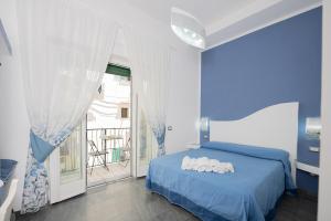 a blue bedroom with a bed and a balcony at La Magnolia Rooms in Procida