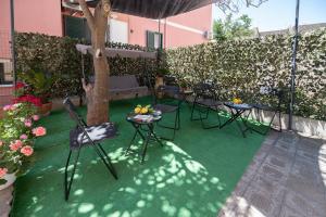 a patio with chairs and a table and a tree at La Magnolia Rooms in Procida