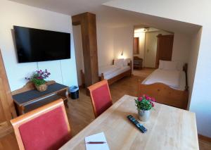 a hotel room with a dining table and a bedroom at Hotel Terofal in Schliersee