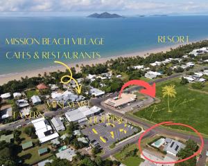 uma vista aérea de uma aldeia de praia com uma seta vermelha a apontar para um resort em Forever Endeavour em Mission Beach