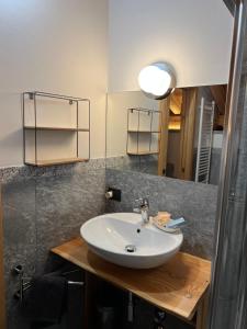 a bathroom with a sink and a mirror at B&B Casa il sasso in Pinzolo