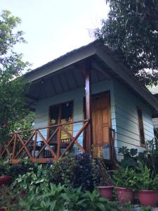 a small blue house with a wooden door at Bungalow Paer Doe in Sembalunbumbung
