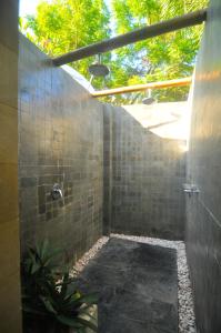 a bathroom with a walk in shower with a roof at The Haven in Gili Trawangan
