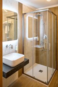 un baño con lavabo y ducha en Motel Eden, en Rîmnicu Sărat