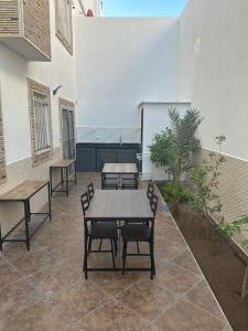 um pátio com mesas e cadeiras num edifício em Villa famillial avec piscine Founty em Agadir