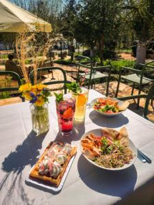 Riverfront Cabins in the garden في بوزنان: طاولة عليها أطباق من المواد الغذائية والمشروبات